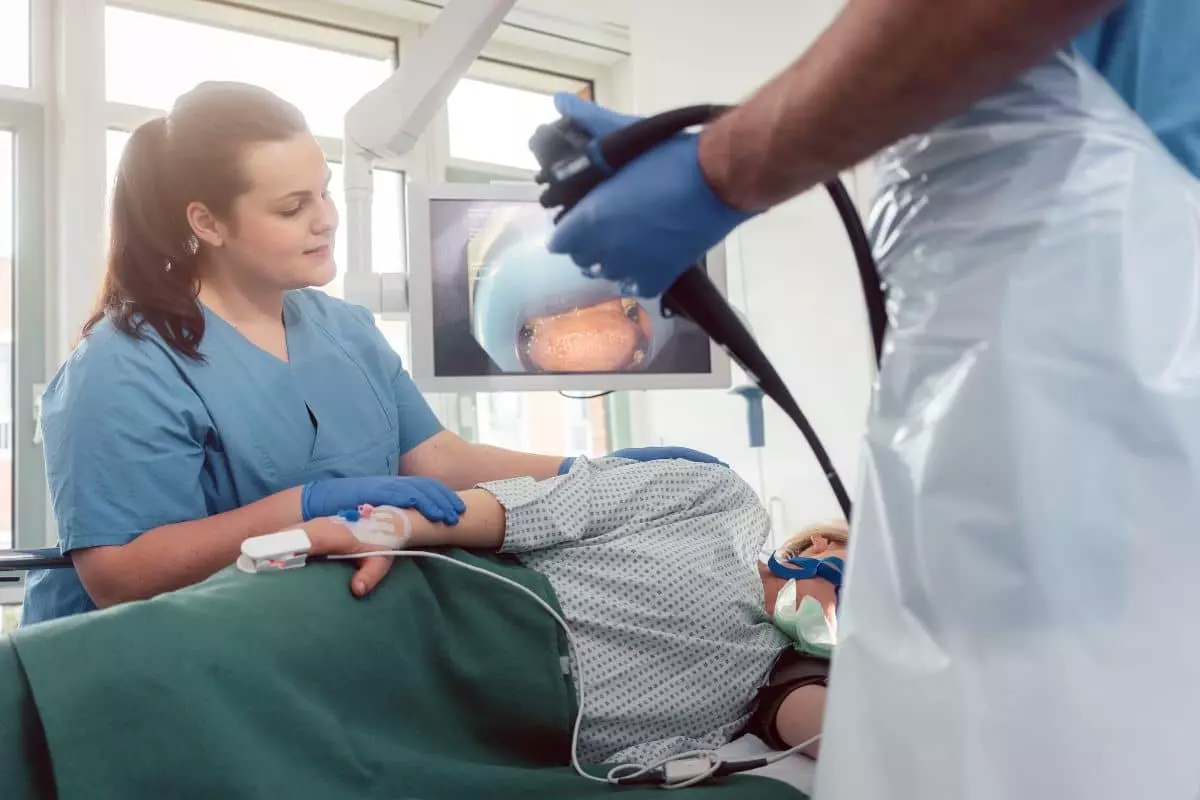 Paciente en examen de endoscopia tradicional con doctor y enfermera